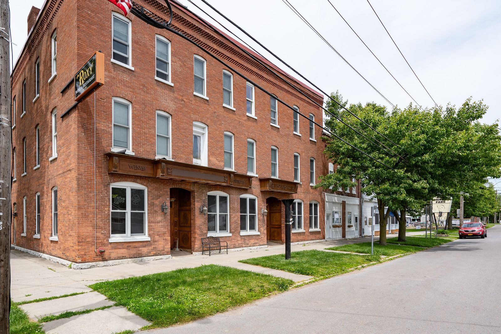 A large brick building with a red car parked in front of it