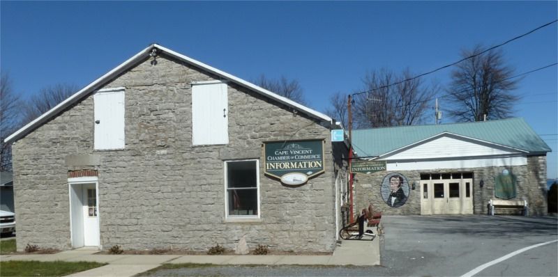 A brick building with a green roof and a sign on it