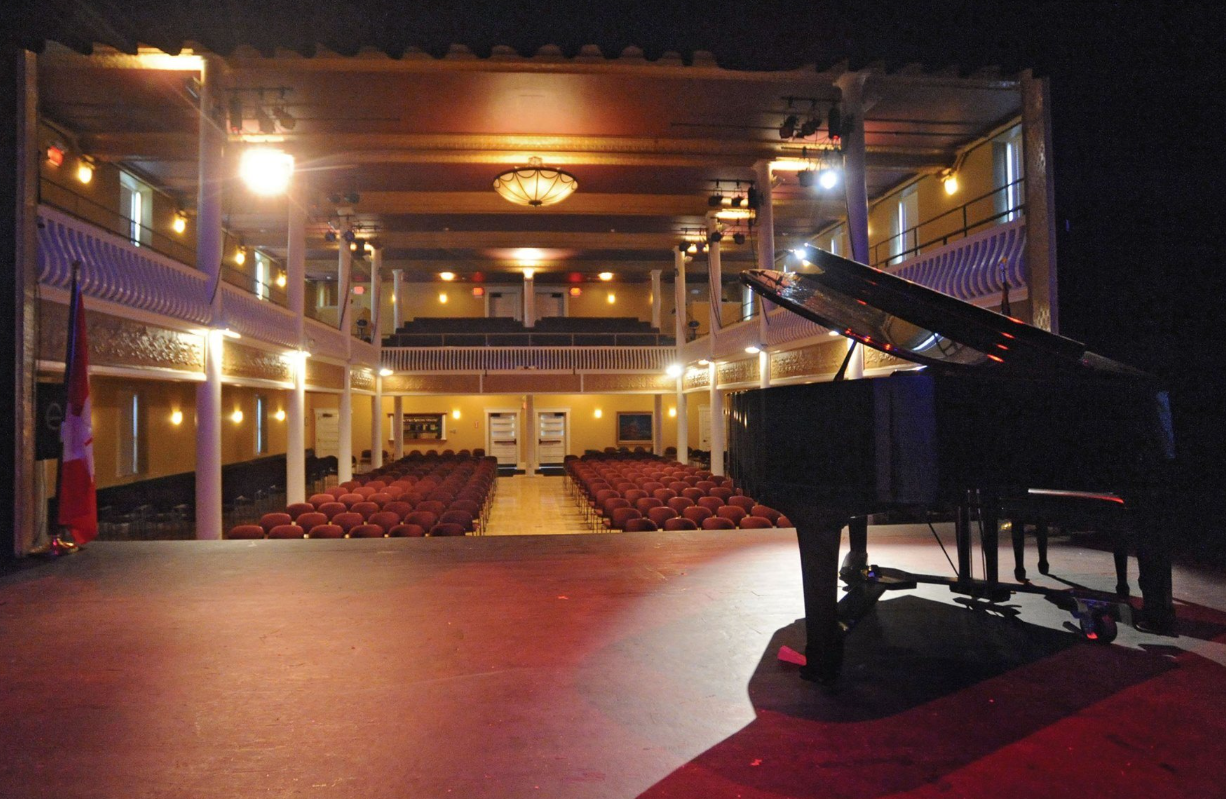 An empty auditorium with a piano on the stage