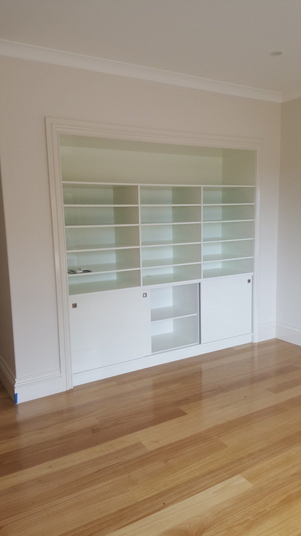 View of wooden flooring and kitchen shelves
