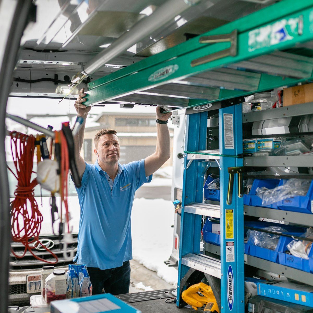 A man in a blue shirt is working in a van