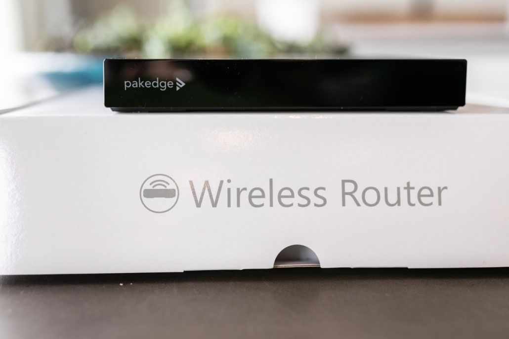 A wireless router is sitting on top of a white box