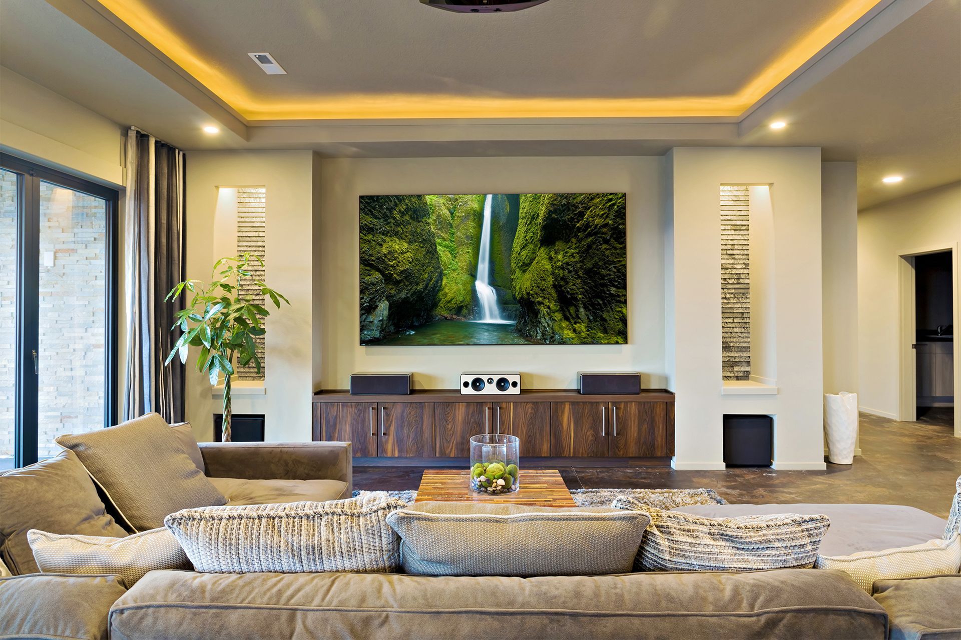 A living room with a large picture of a waterfall on the wall