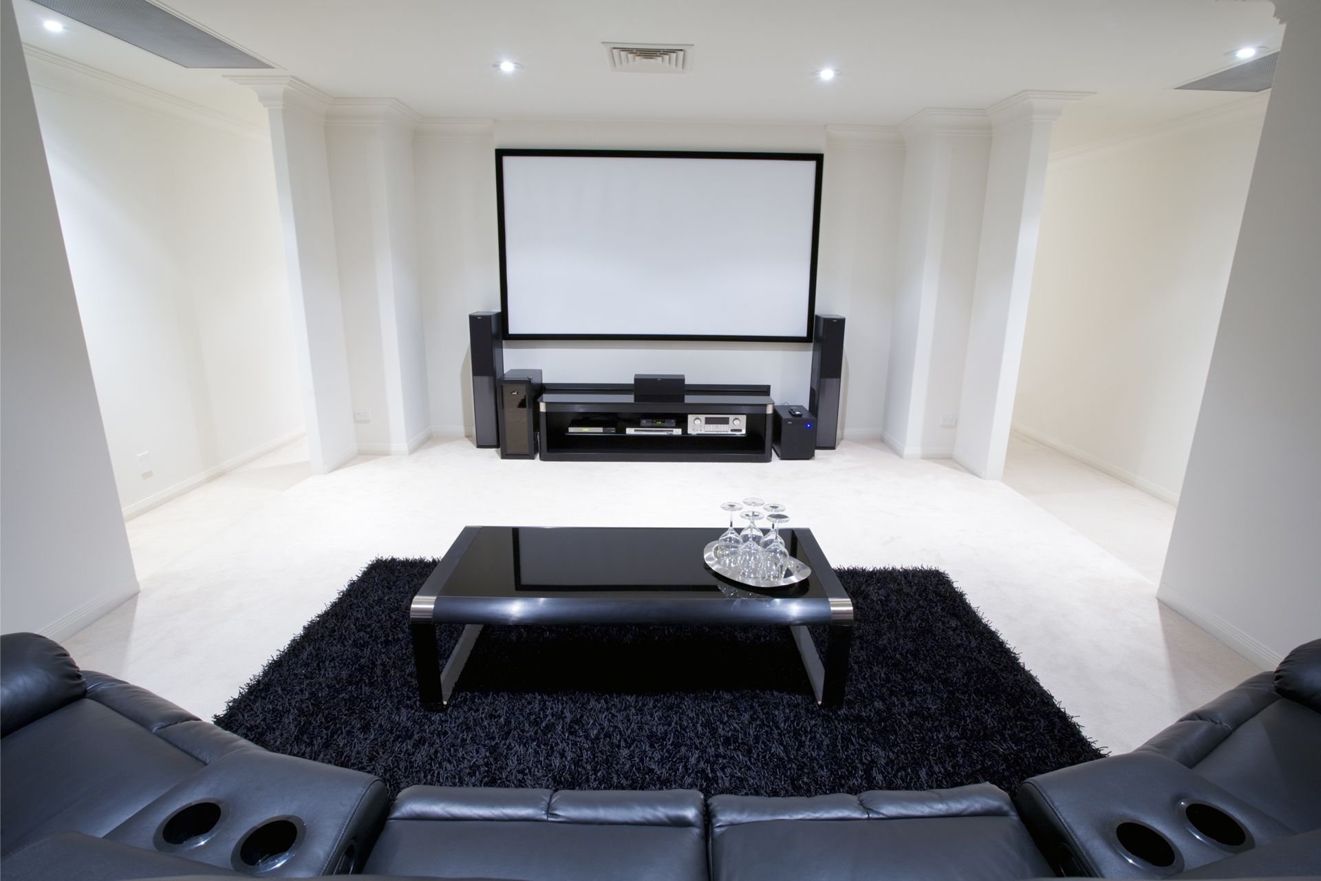 A living room with a projector screen and a couch