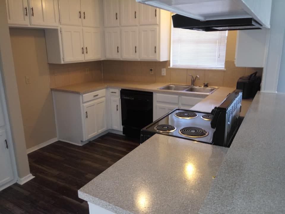 a kitchen with white cabinets and a stove top oven