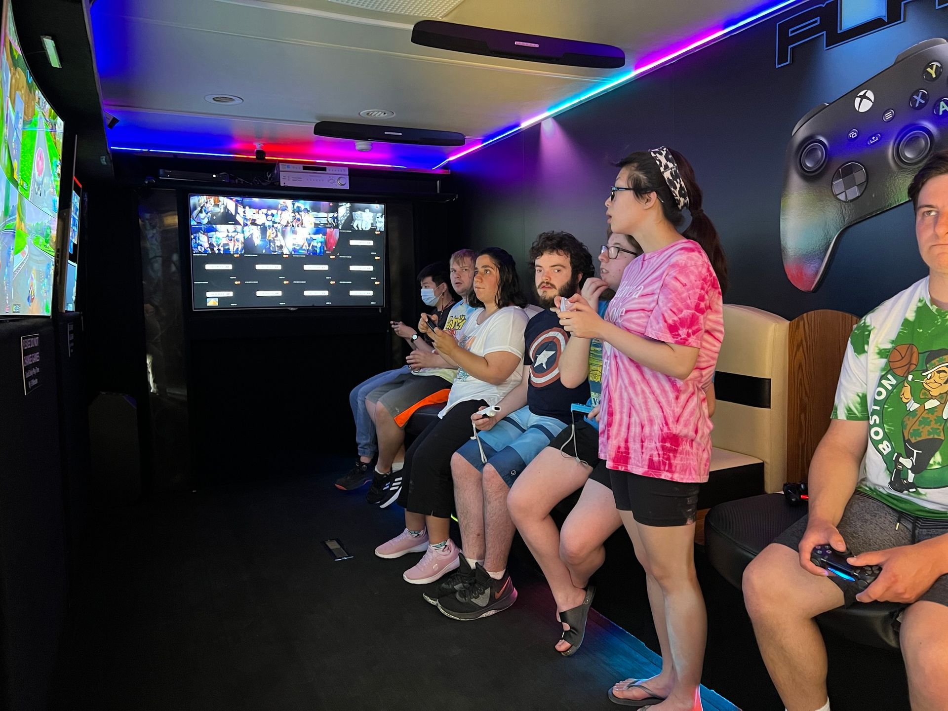 a group of people are sitting in a room playing video games