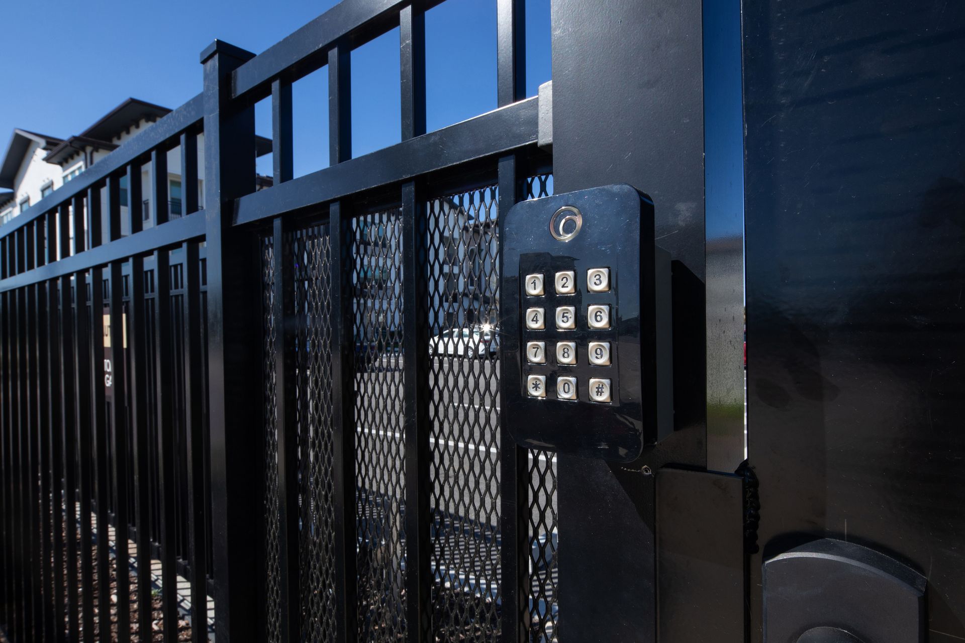 Black metal security gate with keypad entry.