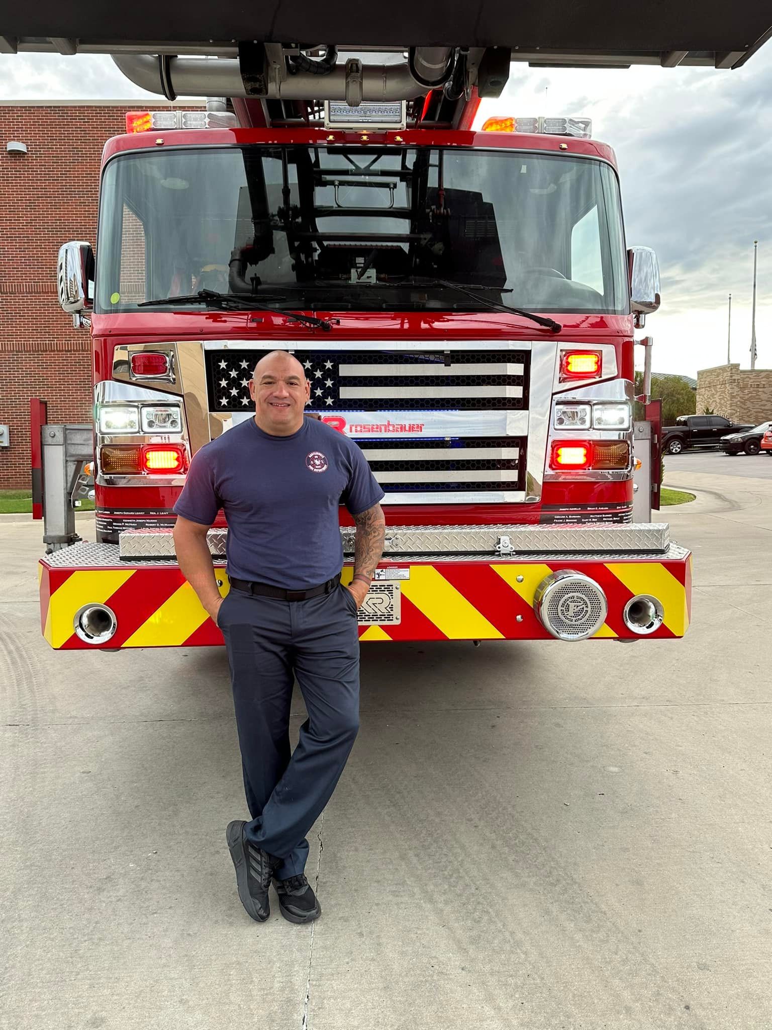 A man is standing in front of a fire truck.