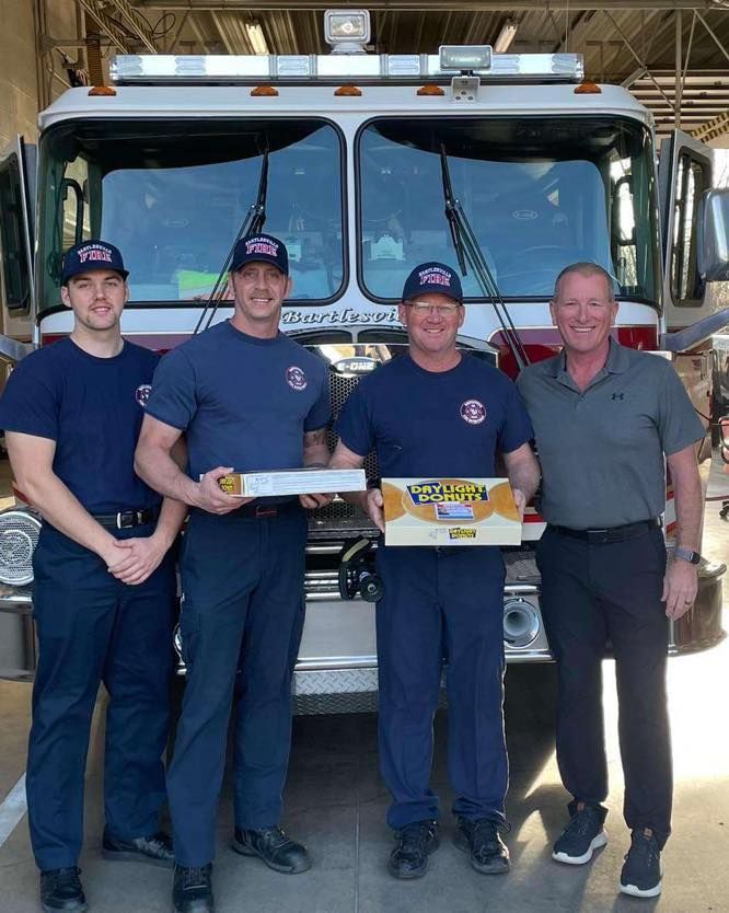 A group of men standing in front of a fire truck