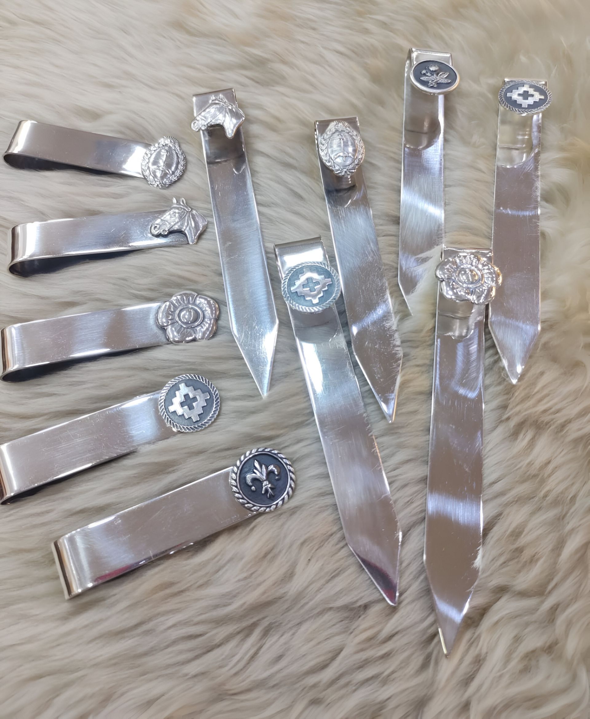 Señaladores y sujeta dinero plateados se encuentran sobre una superficie peluda.