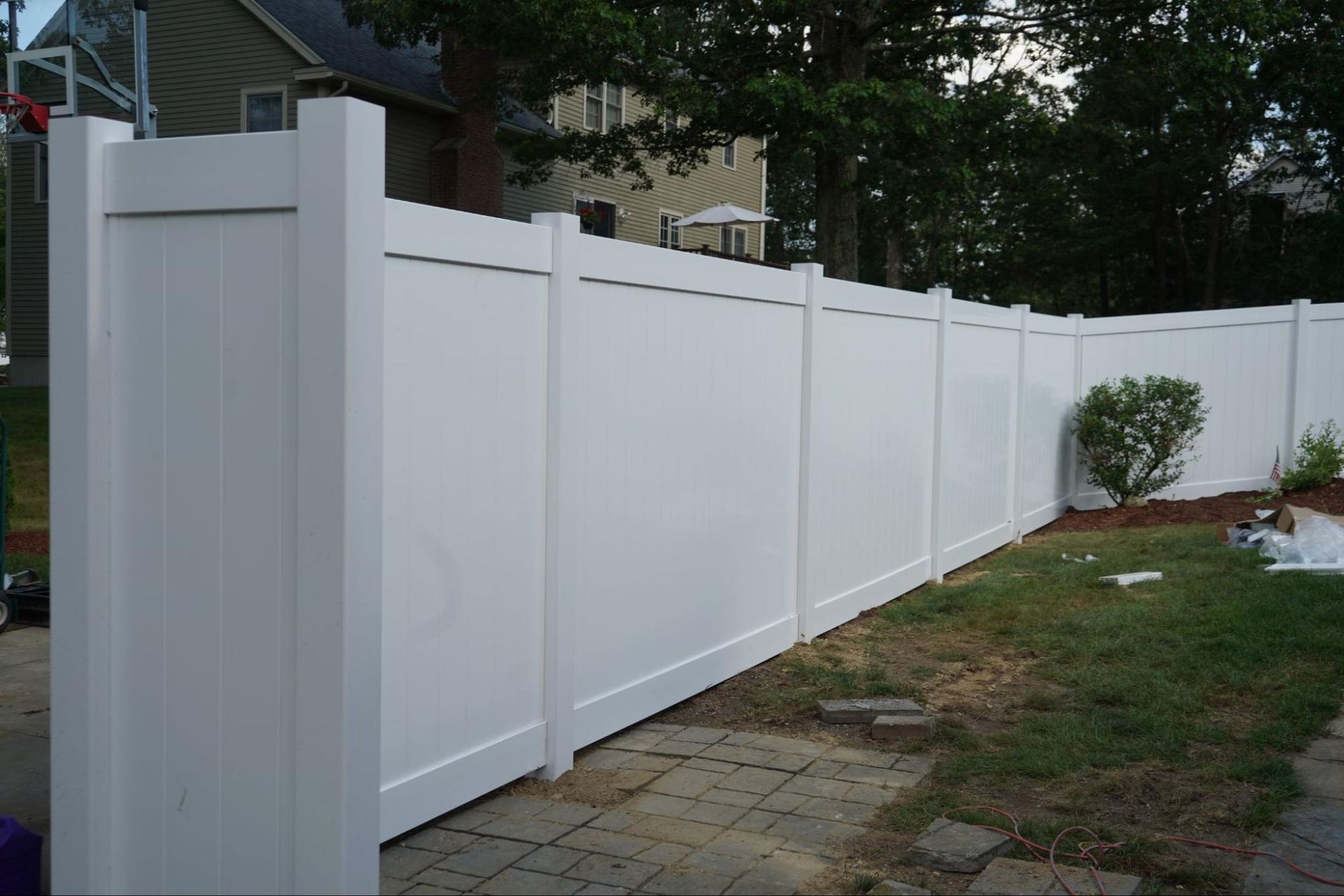 White vinyl fence in a backyard.