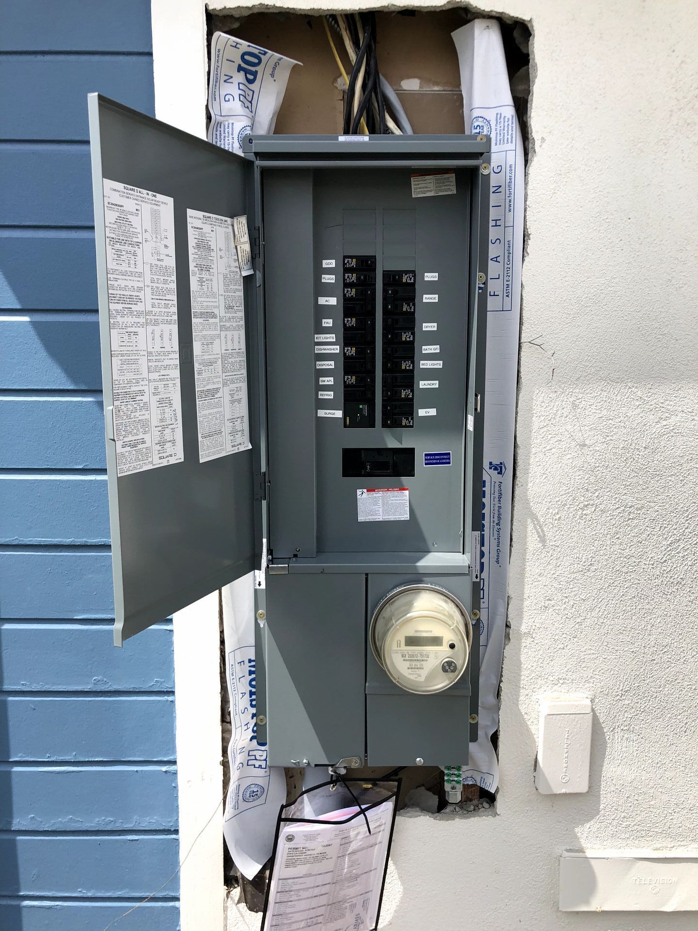 A electrical box on a wall with the door open