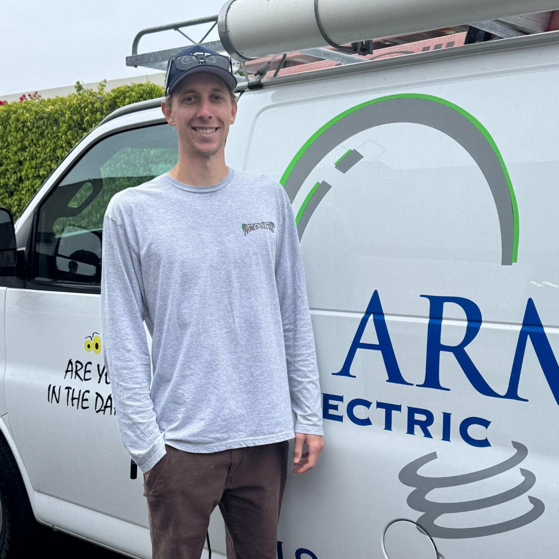 A man is standing in front of an ar electric van