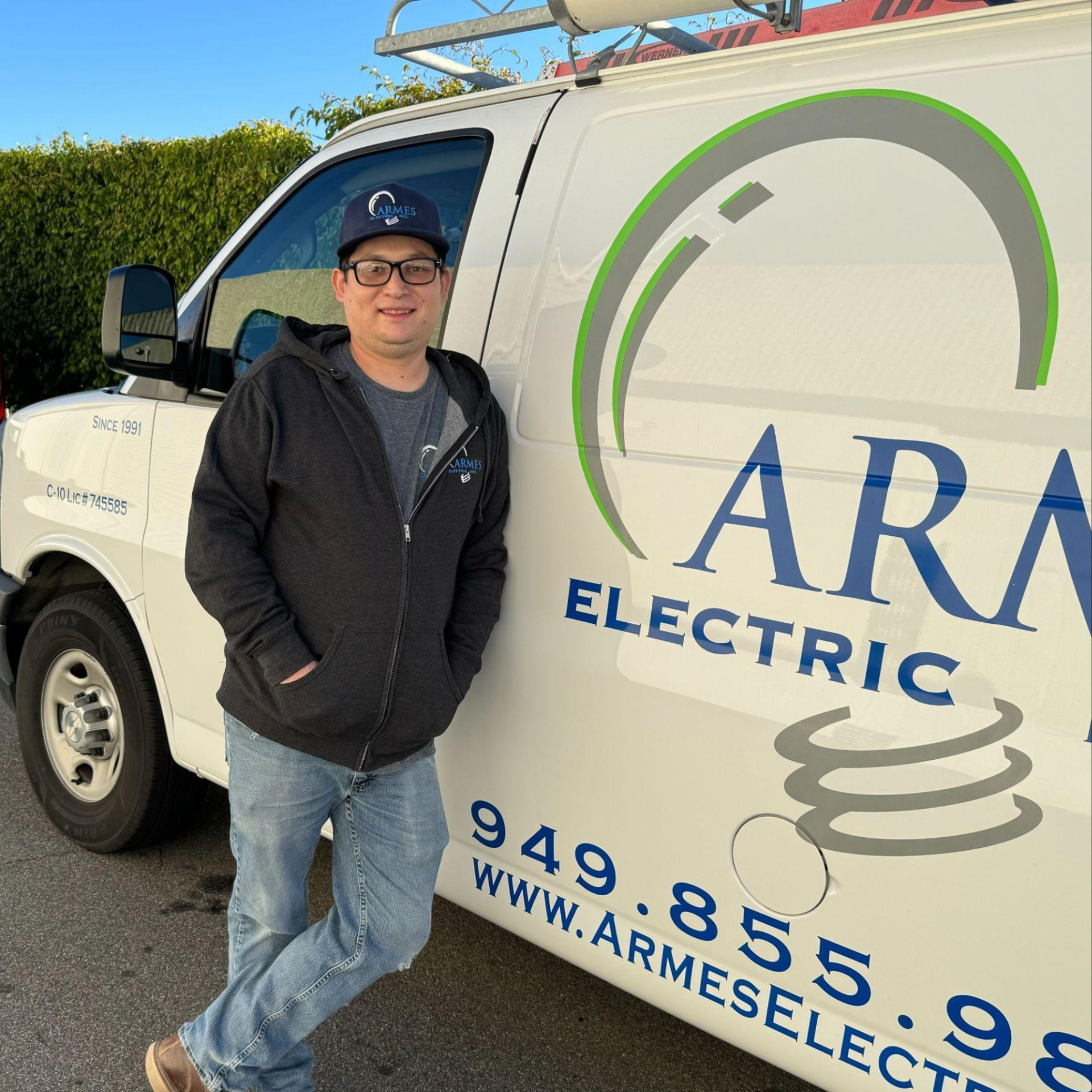 A man is standing in front of a van that says rme ric inc.