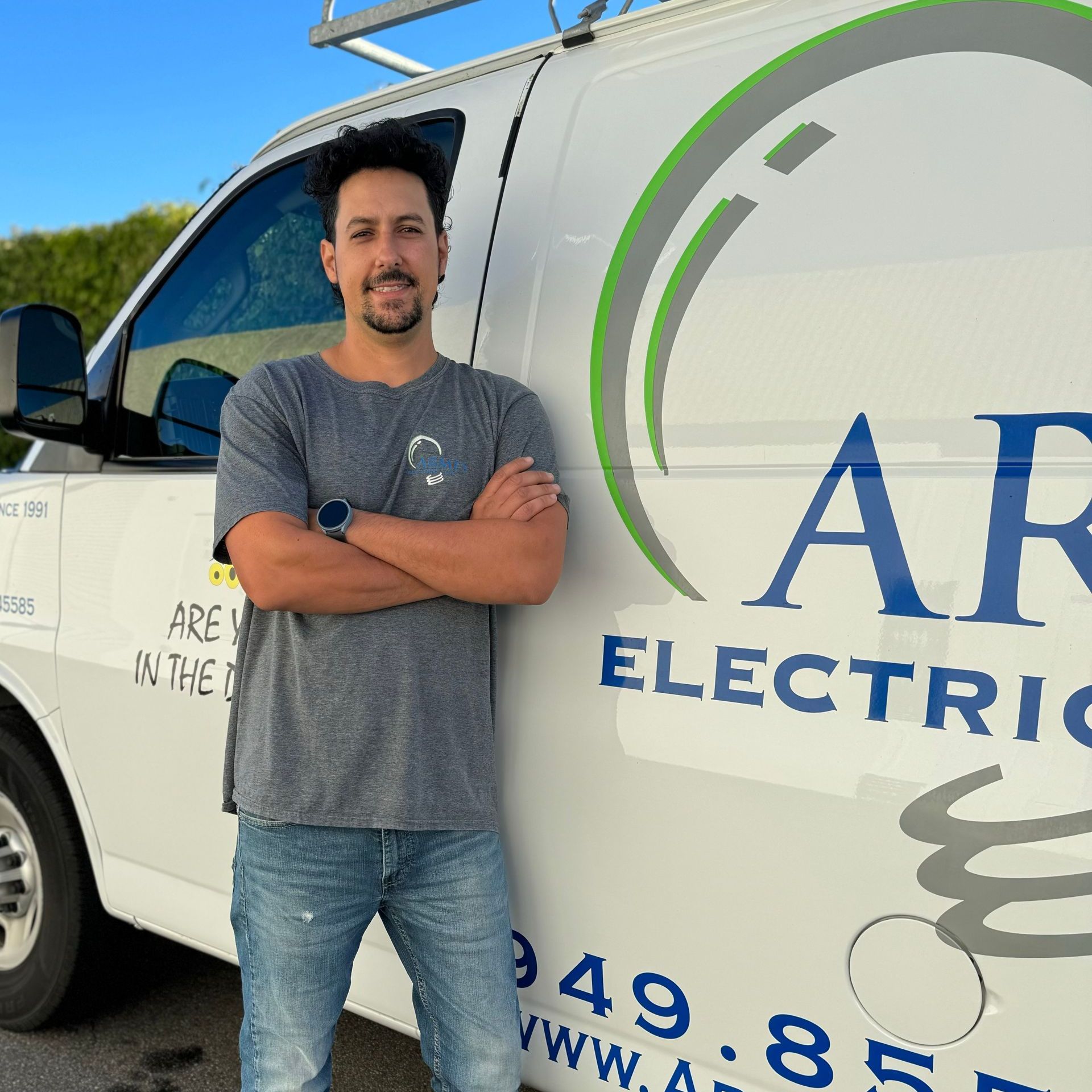 a man stands in front of a van that says armes electric