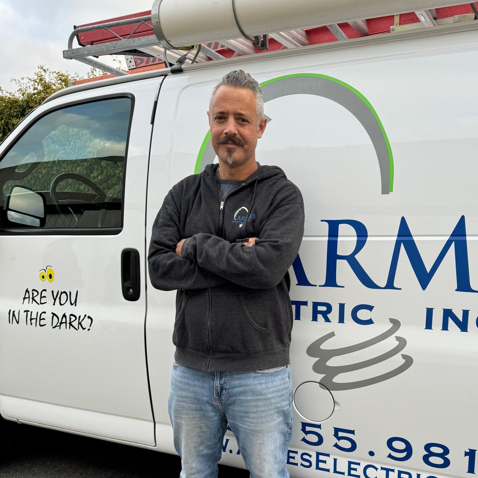 a man stands in front of an arm electric van