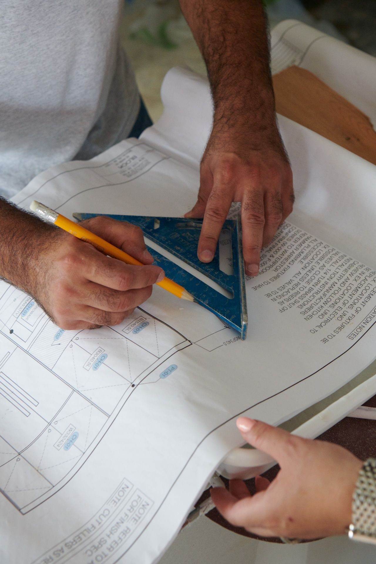 A man is using a triangle to measure a piece of paper.