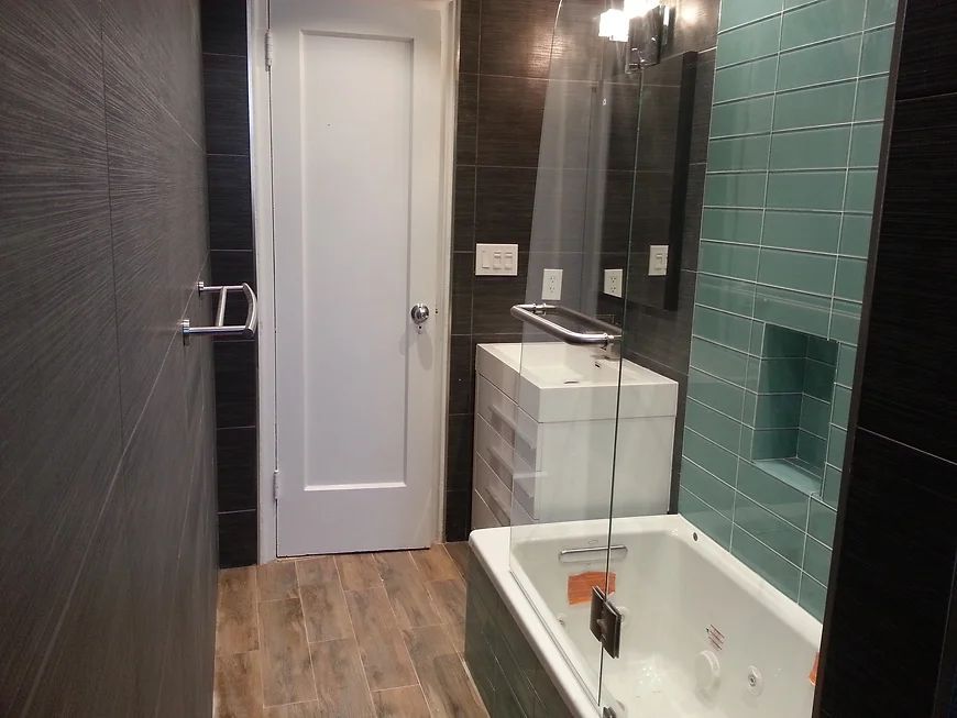 A bathroom with a tub, sink and mirror