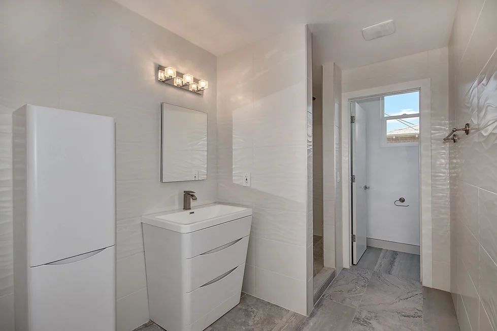 A bathroom with a sink, mirror and cabinets.