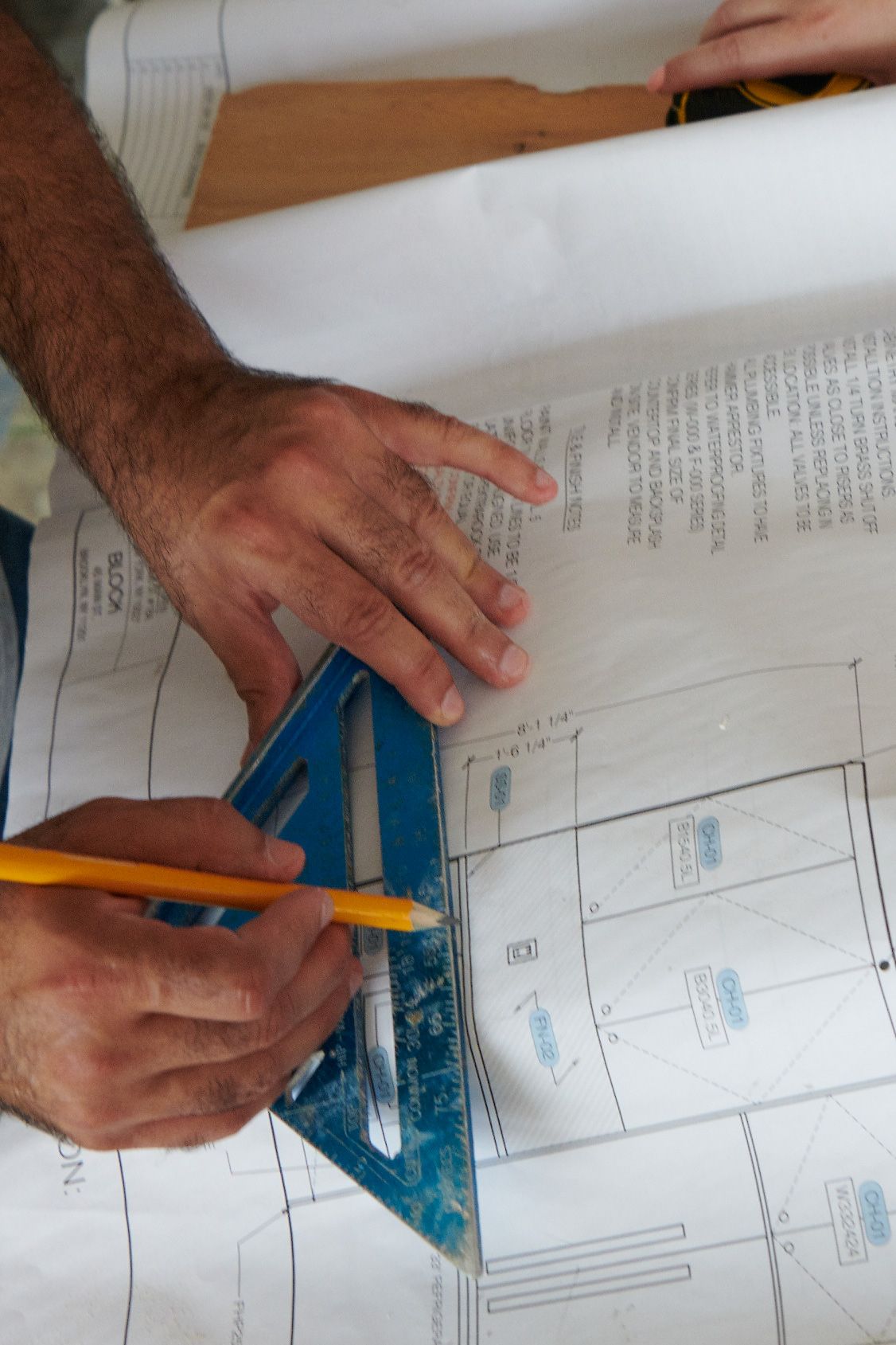 A person is measuring a piece of paper with a ruler