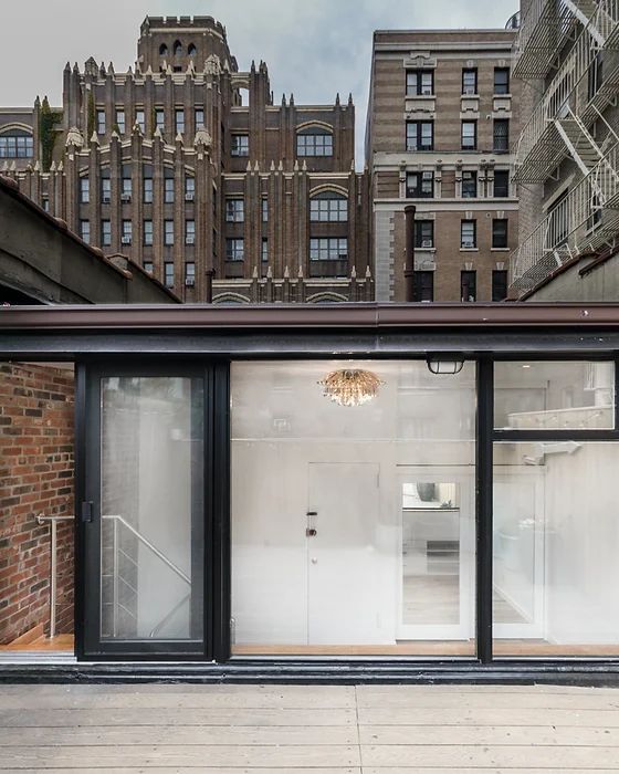 A man and a woman are measuring a counter in a room.