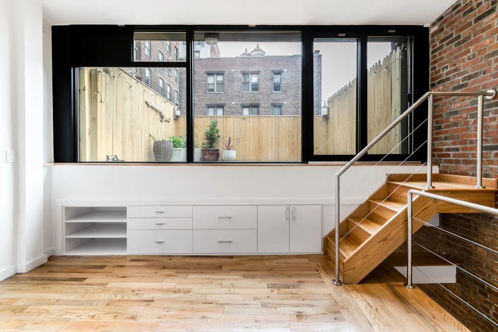 A man and a woman are looking at a blueprint on a table.