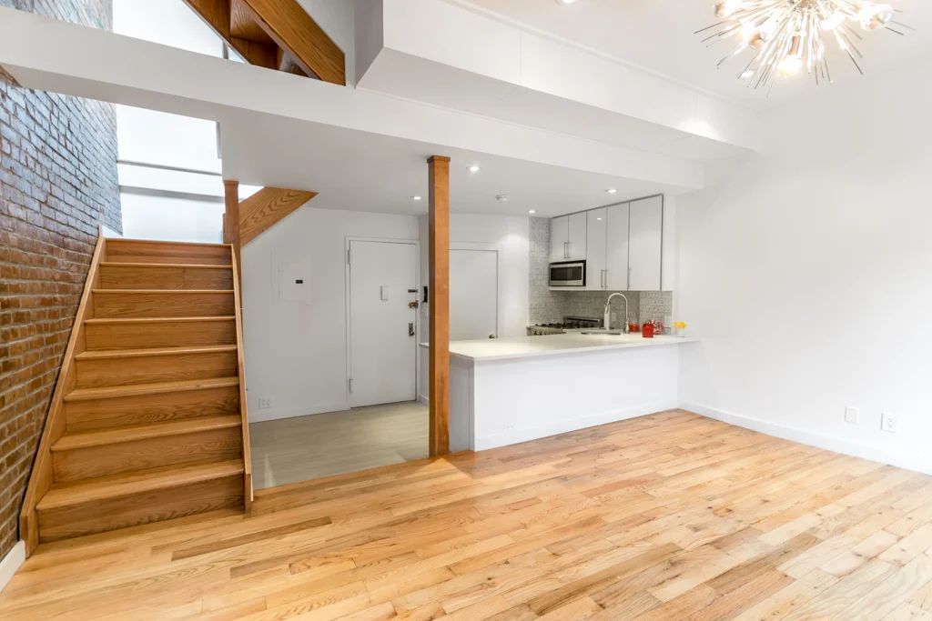 A kitchen with stools a table and a window.