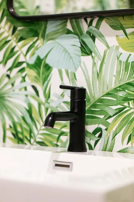 A shower with a shower head and a shelf with bottles on it.