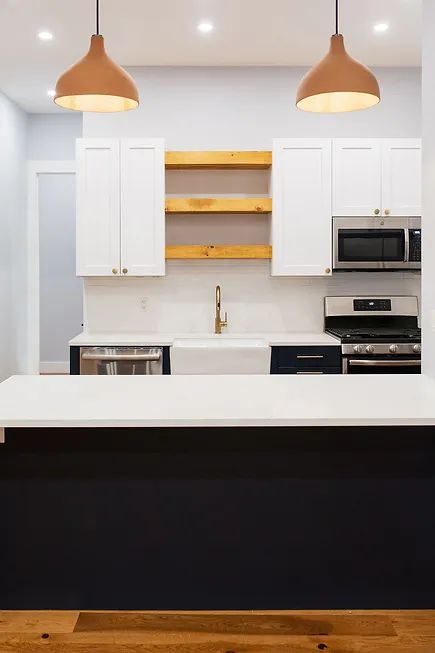 A bathroom with a toilet, sink, mirror and shower.