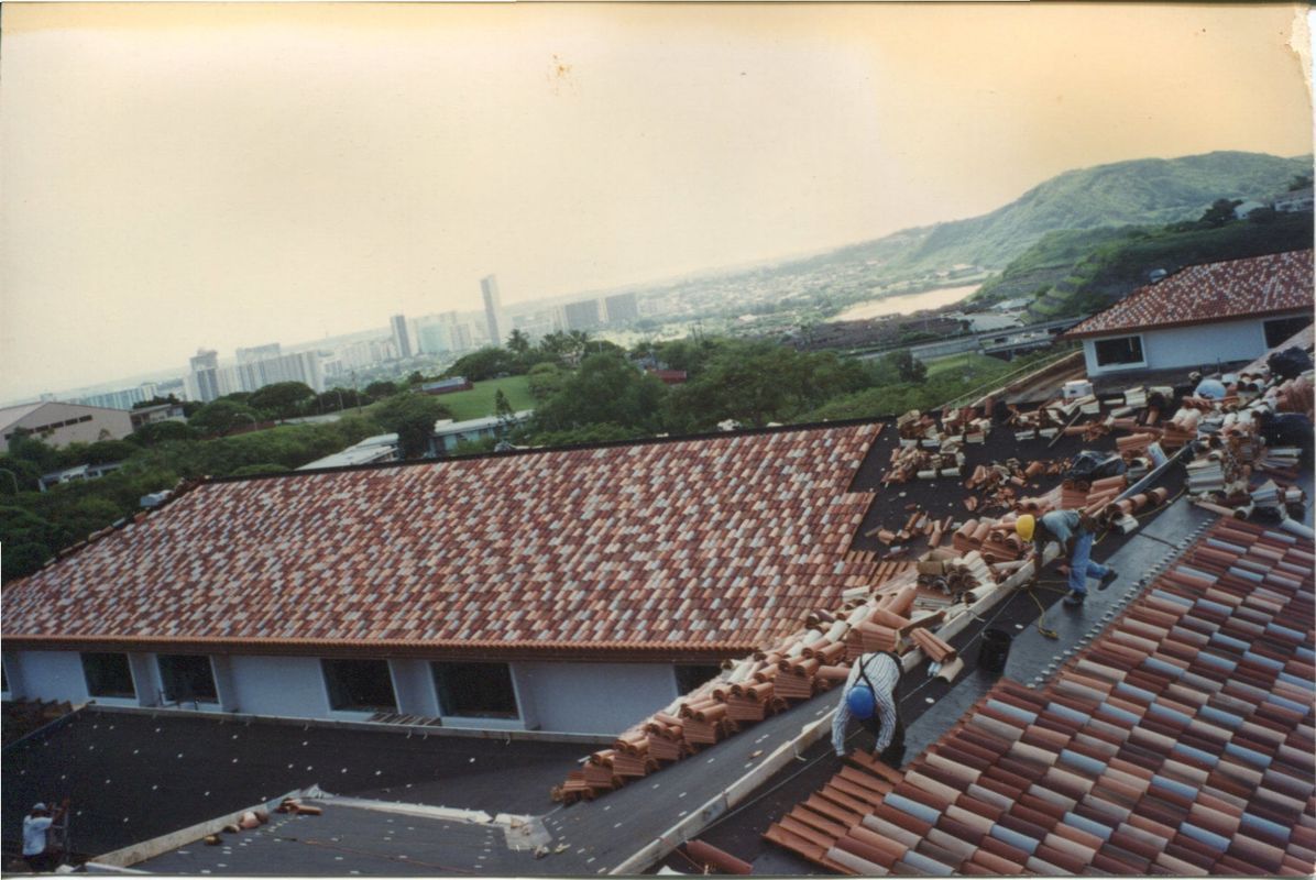 A group of people are working on the roof of a house