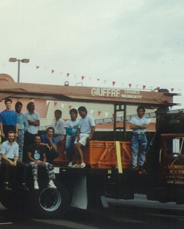 A group of people standing in front of a truck that says guffre