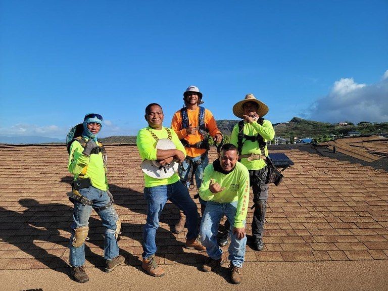 A group of construction workers are posing for a picture on a roof
