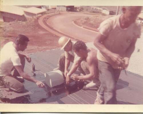 A group of men are working on a roof.