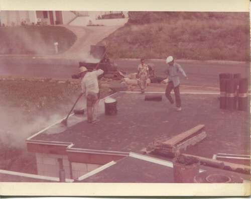 A group of people are working on a roof.