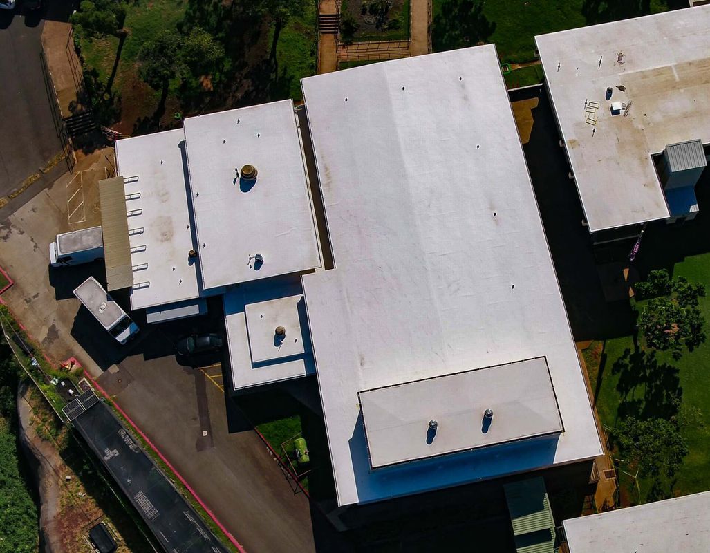 An aerial view of a building with a white roof