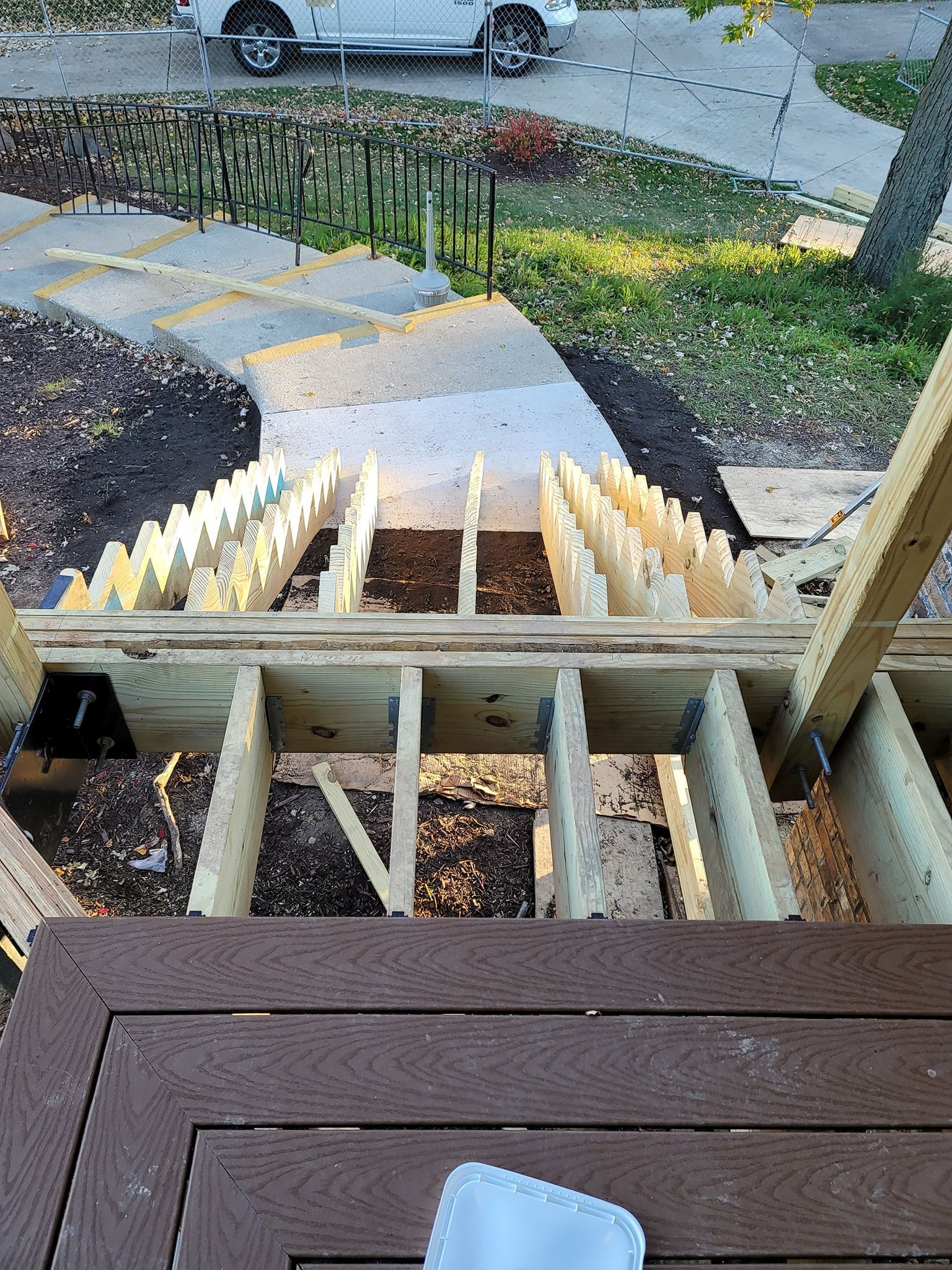 View from a deck of a staircase under construction, with exposed wood framing.