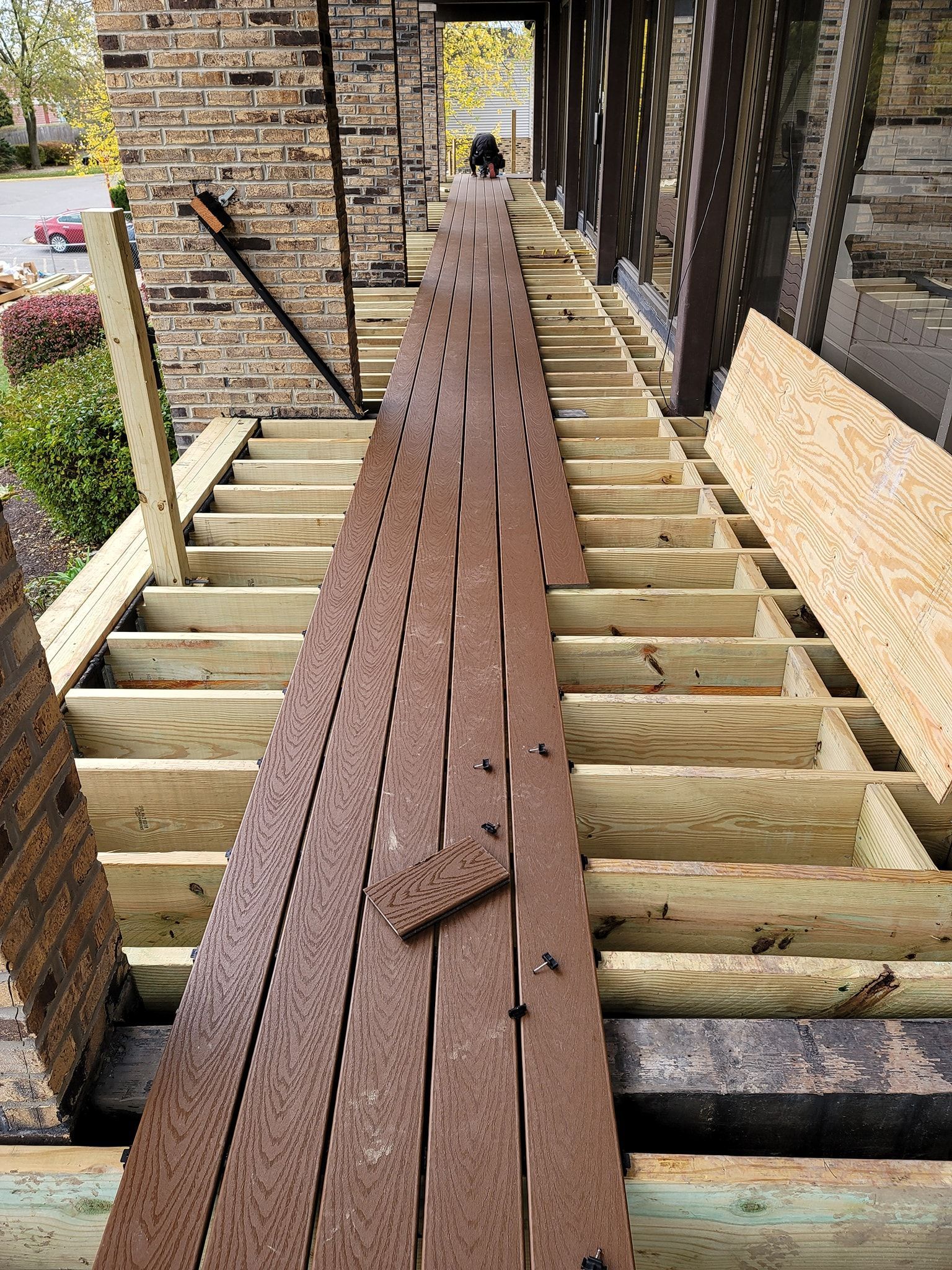 Deck under construction; brown composite decking boards laid on a wood frame.