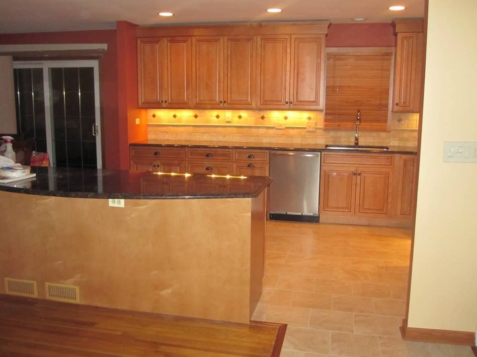 Kitchen with wooden cabinets, stainless steel appliances, and a dark countertop island.