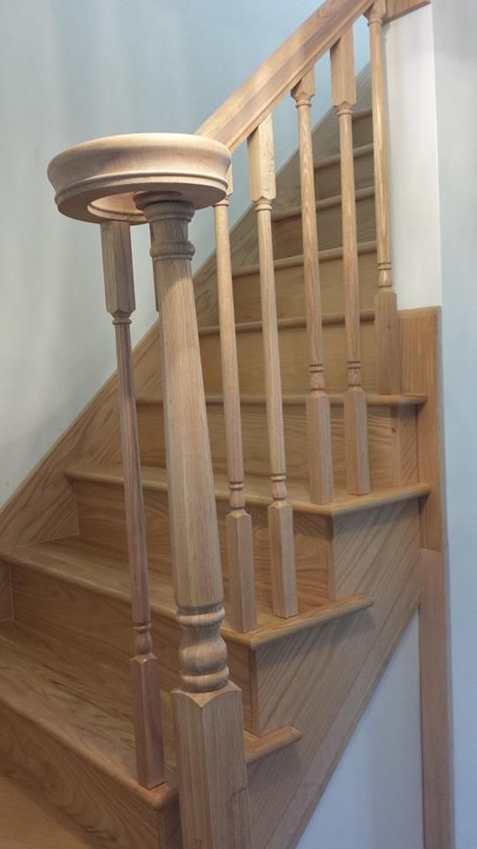 Wooden staircase with banister and balusters. Light-colored wood, right-angled steps.
