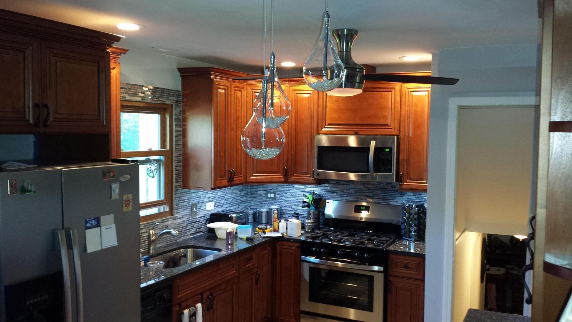 Kitchen with wood cabinets, stainless steel appliances, and two pendant lights.