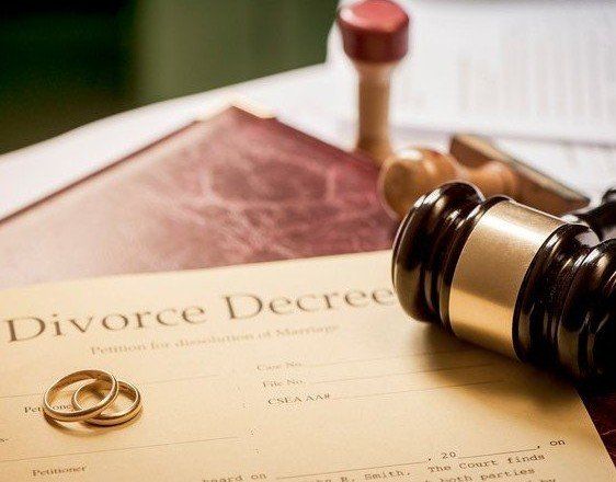 a pair of wedding rings are sitting on top of a divorce decree .