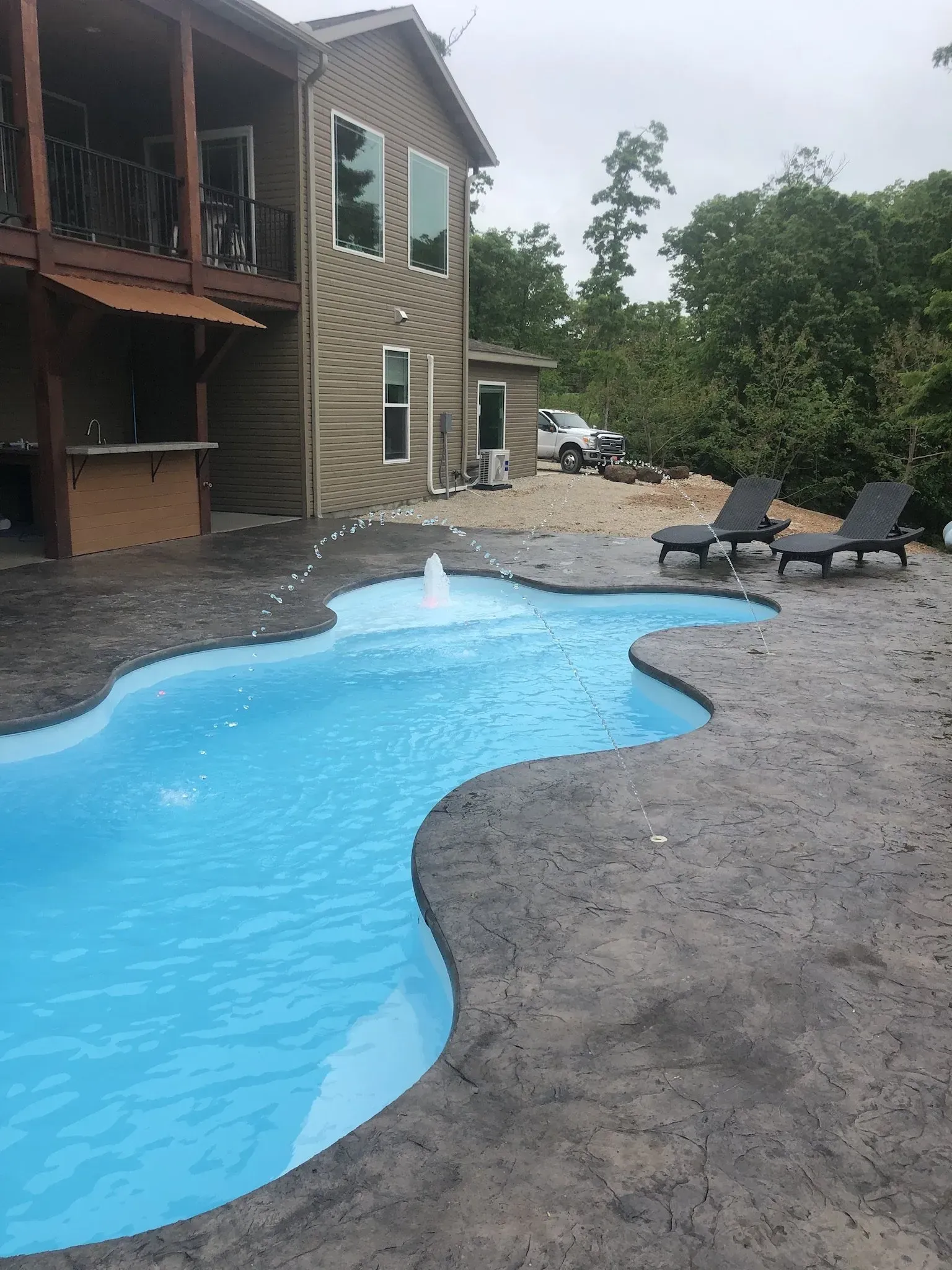 freeform pool with stamped concrete pad