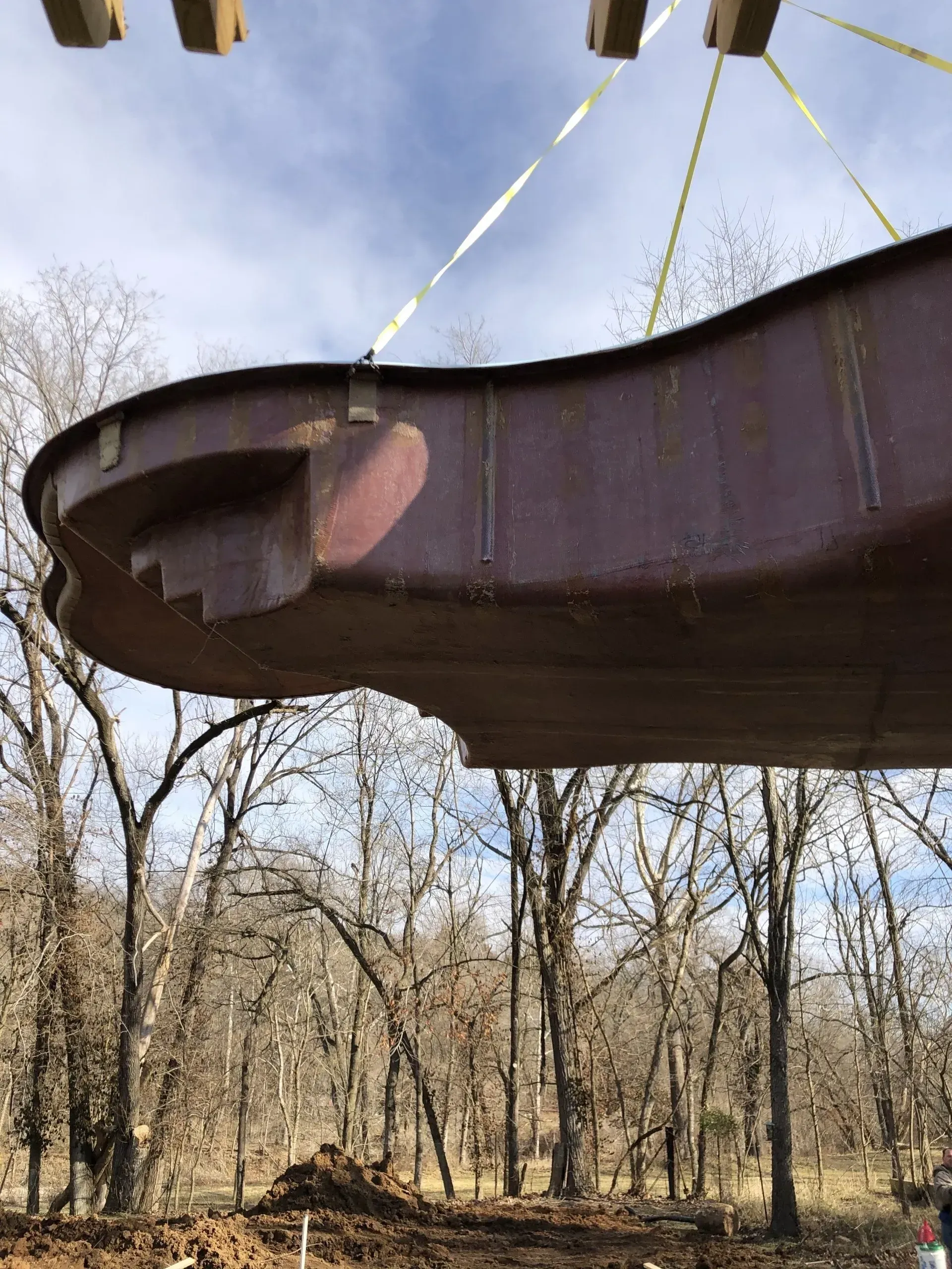 pool being held up by a crane before being lowered in the ground