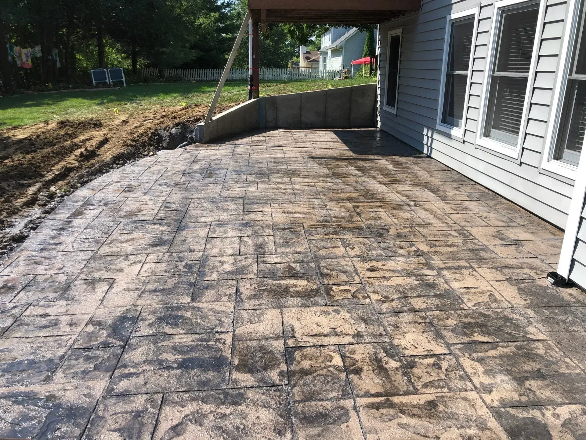 stamped and stained concrete back patio with view of yard