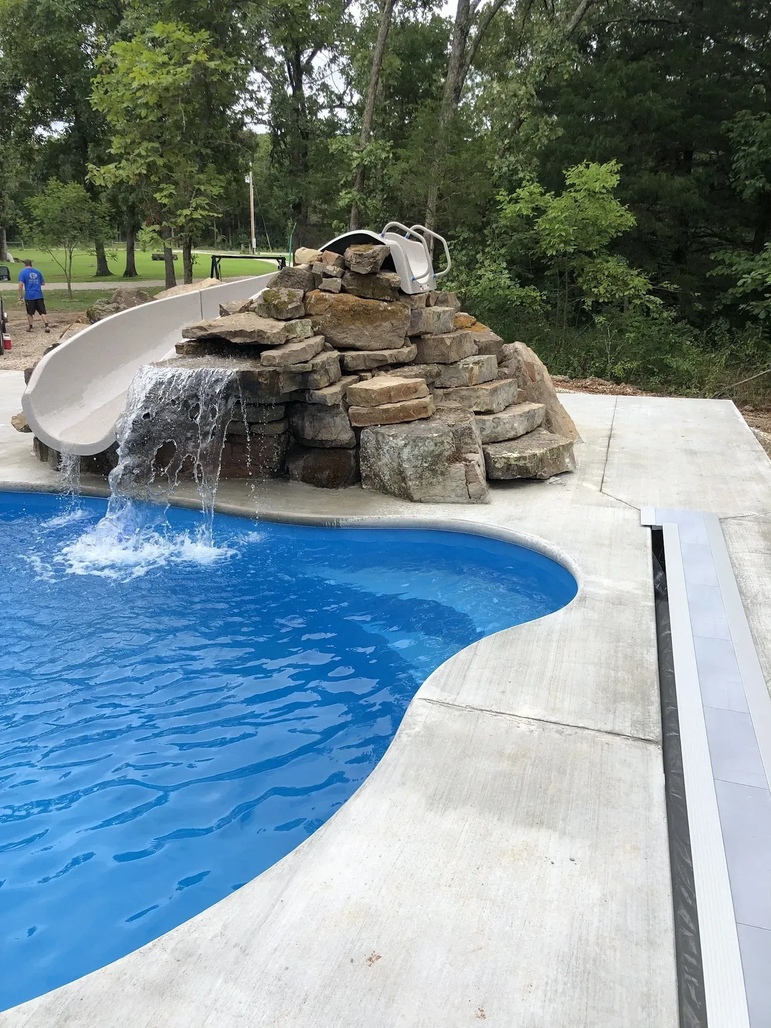 Pool with rock wall waterfall and slide