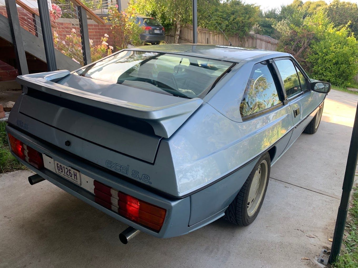 A blue sports car is parked in a driveway.