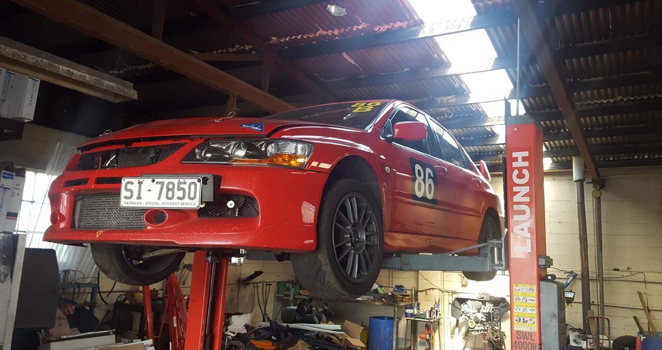 The inside of a race car with the hood open and a sparco seat.