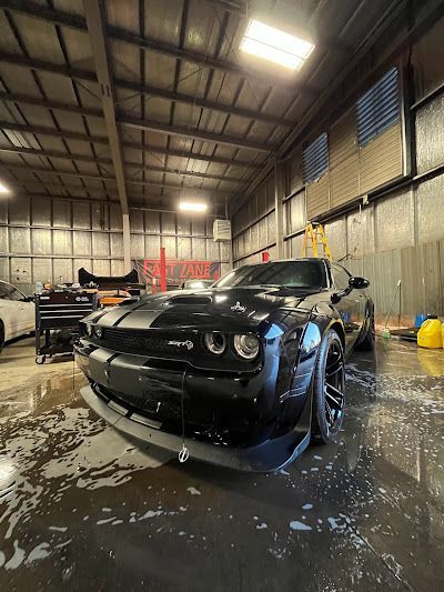 A black dodge challenger is parked in a garage.