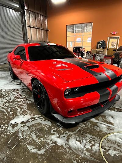 A red dodge challenger is sitting in a garage.