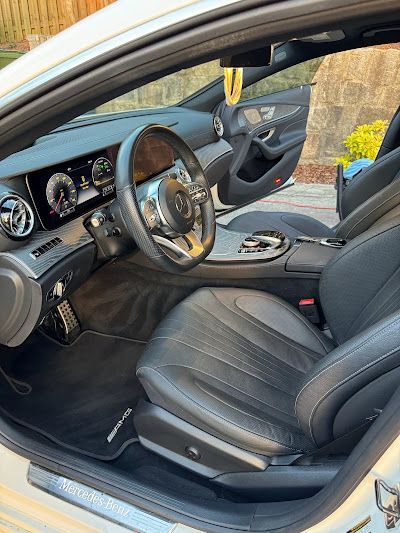 The interior of a white car with black seats and a steering wheel.